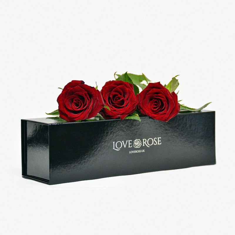 3 red forever roses arranged on a luxury black box